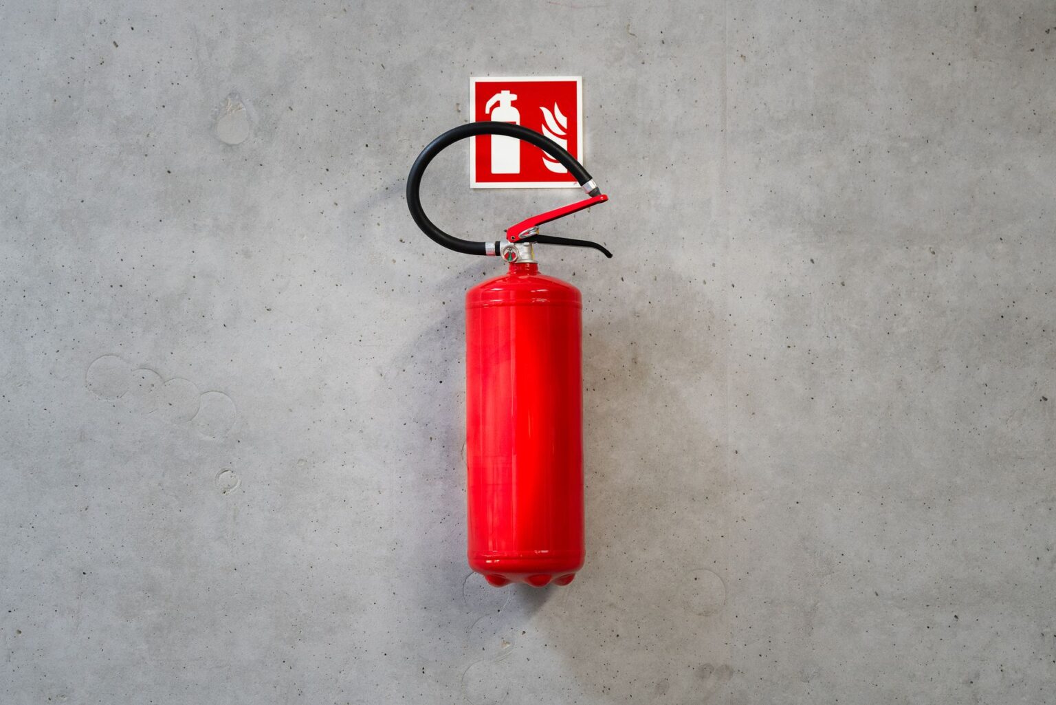 Extincteur sur mur béton, avec sa signalétique