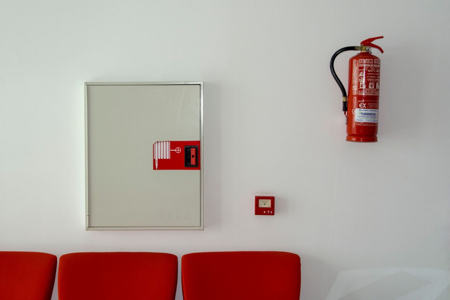 Extincteur et matériel de sécurité incendie sur un mur clair à Agde