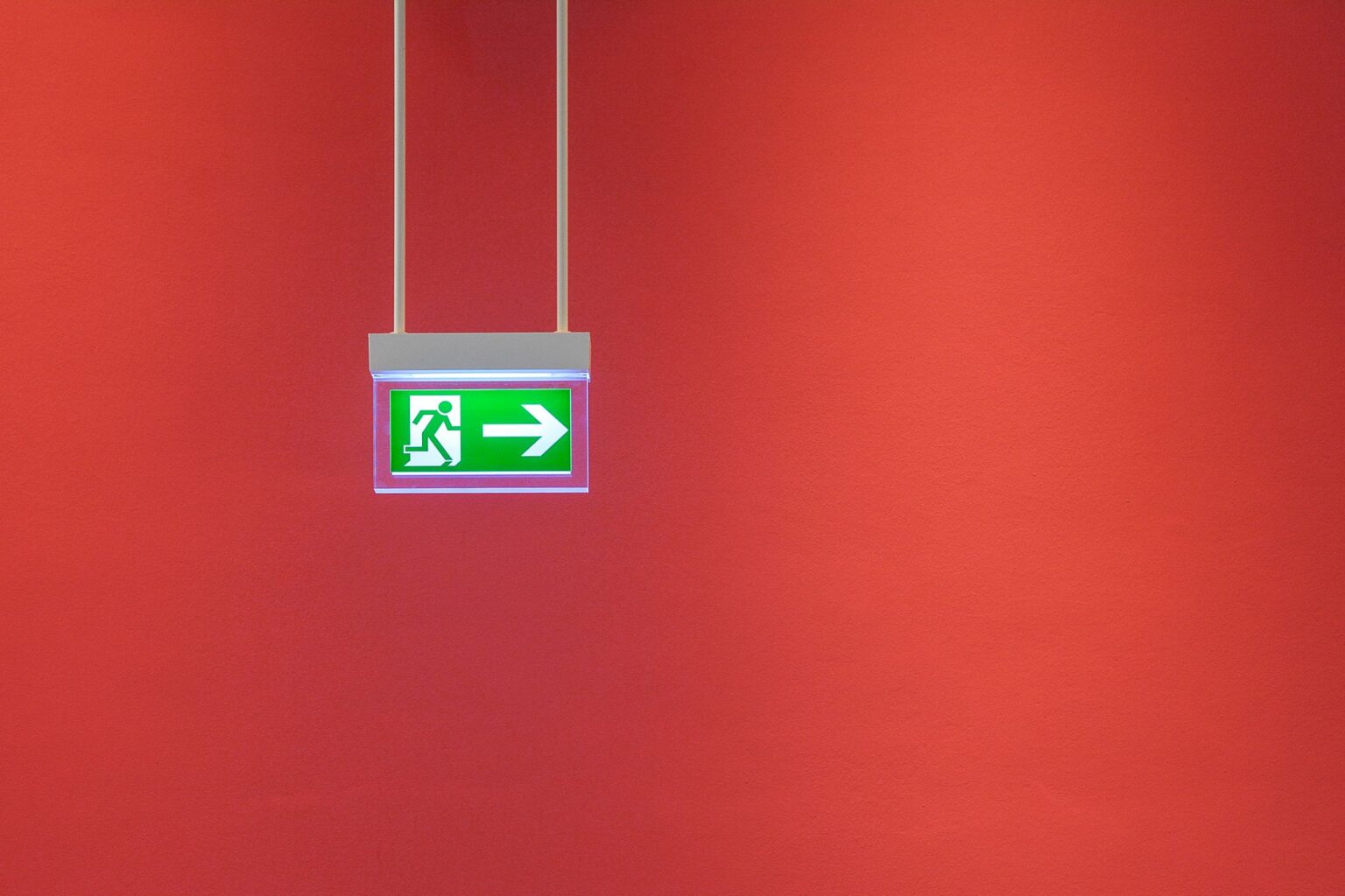 Bloc de secours fléché sur un mur coloré