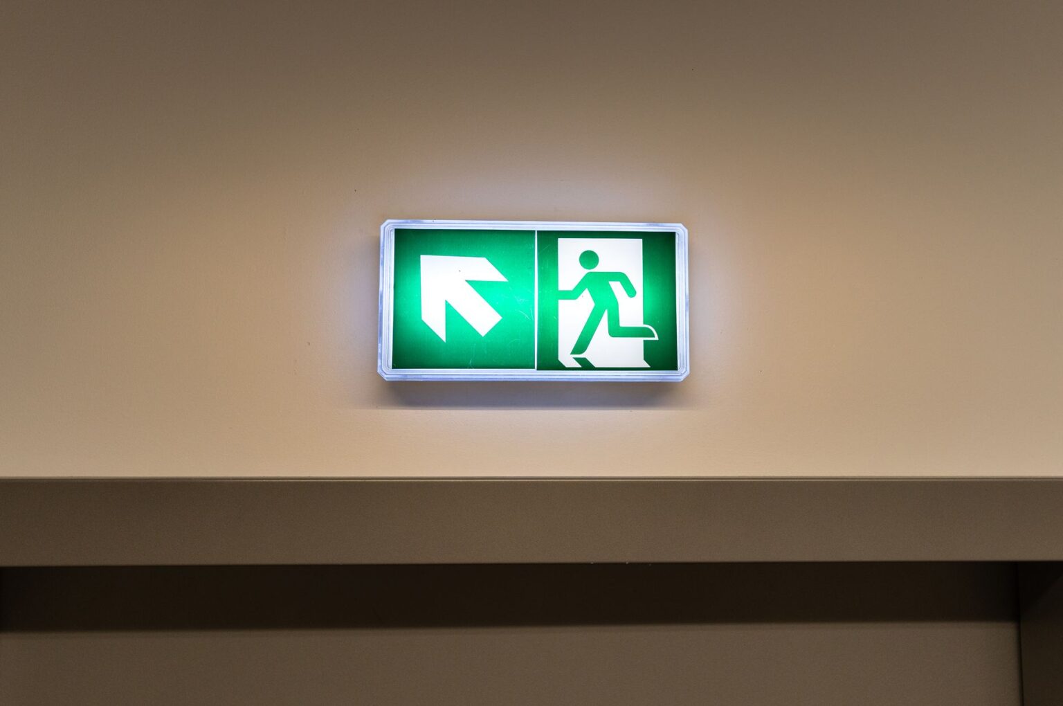 Bloc d'évacuation fléché dans un couloir